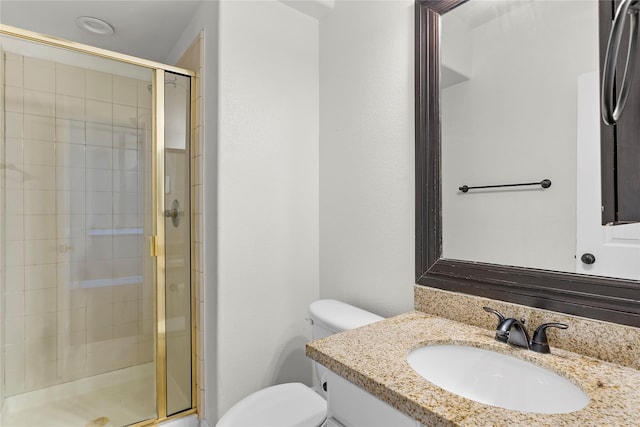 bathroom featuring toilet, vanity, and a shower with shower door