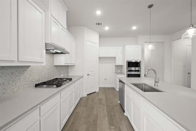 kitchen featuring visible vents, a sink, under cabinet range hood, appliances with stainless steel finishes, and white cabinetry