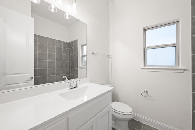 bathroom with baseboards, toilet, tiled shower, tile patterned floors, and vanity