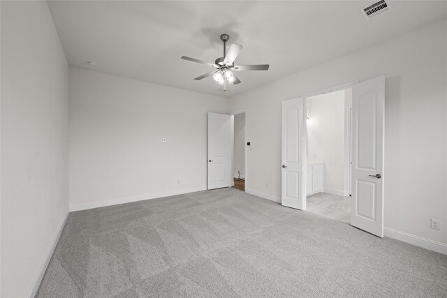 carpeted empty room featuring a ceiling fan, baseboards, and visible vents