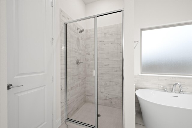 full bathroom featuring a freestanding bath and a stall shower