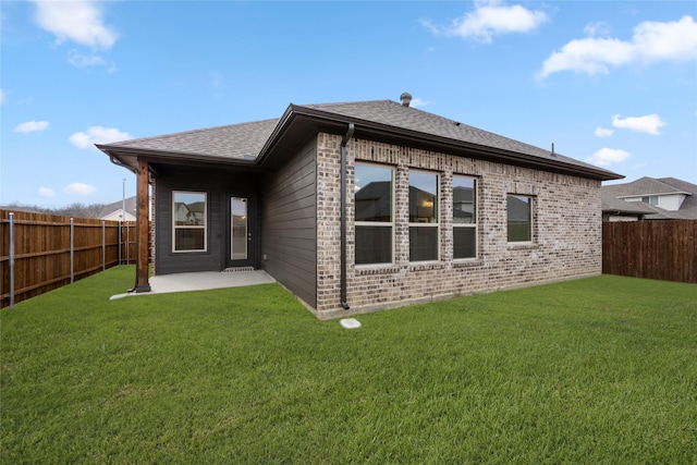 back of property with a patio, a fenced backyard, brick siding, and a lawn