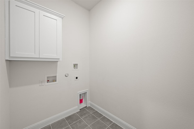 laundry room featuring hookup for a washing machine, baseboards, hookup for an electric dryer, dark tile patterned flooring, and cabinet space