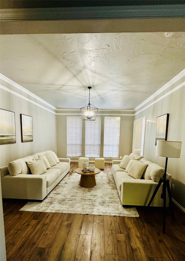 living room featuring crown molding, hardwood / wood-style flooring, and an inviting chandelier