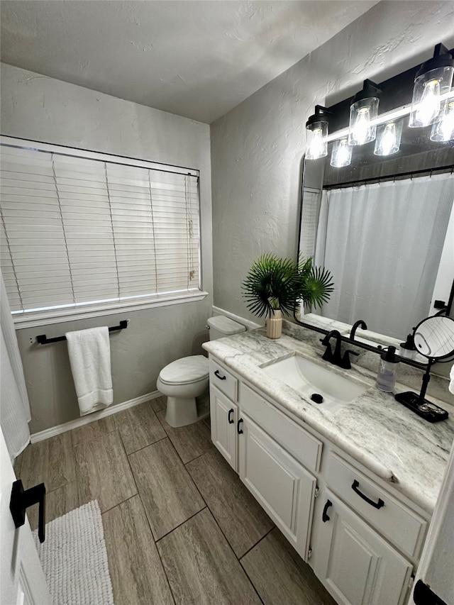 bathroom with vanity, hardwood / wood-style flooring, and toilet