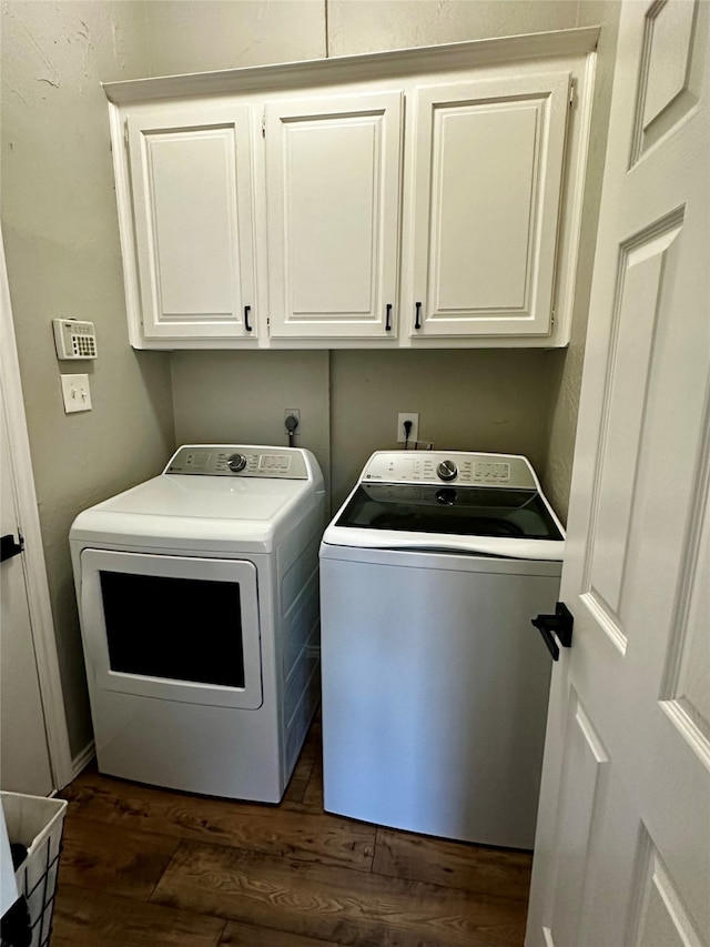 laundry area with independent washer and dryer, cabinets, and dark hardwood / wood-style floors