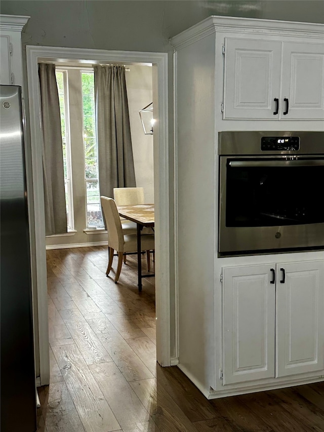 kitchen with white cabinetry, appliances with stainless steel finishes, and dark wood-type flooring