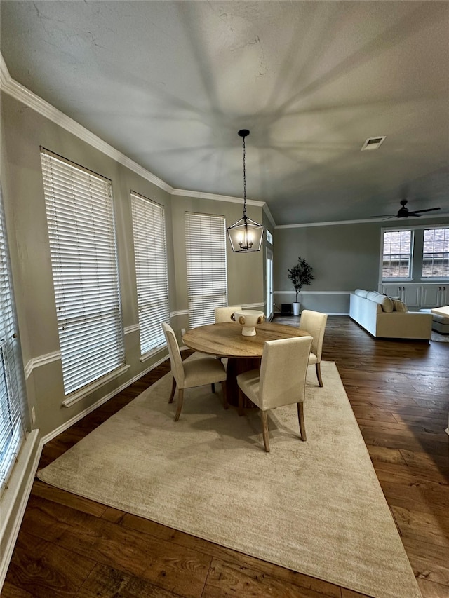 dining area featuring crown molding, a textured ceiling, dark hardwood / wood-style floors, and ceiling fan with notable chandelier