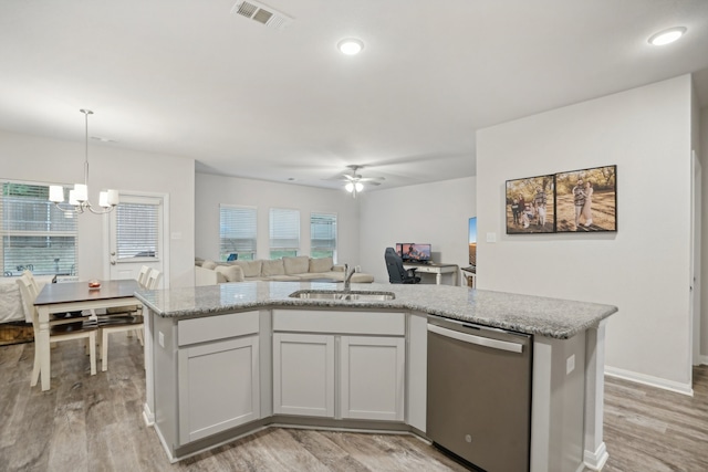 kitchen featuring stainless steel dishwasher, light wood-type flooring, sink, and a kitchen island with sink