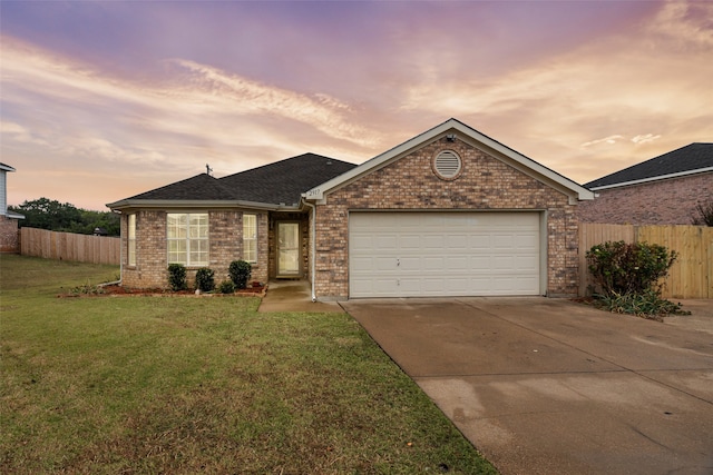 ranch-style home featuring a garage and a yard