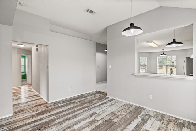 unfurnished room with lofted ceiling and hardwood / wood-style floors