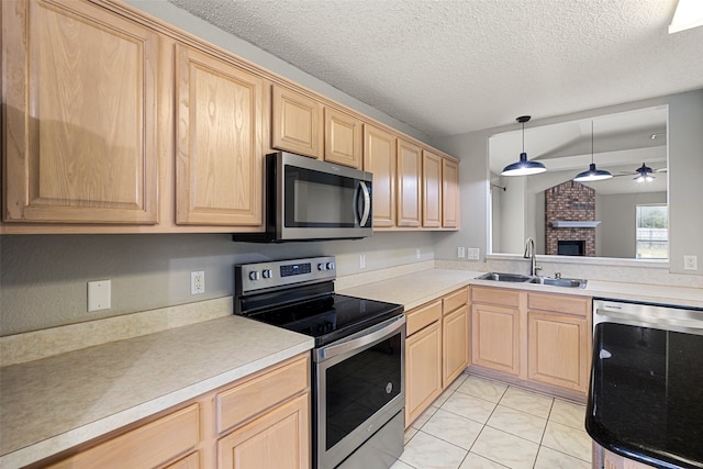 kitchen featuring sink, appliances with stainless steel finishes, light brown cabinets, ceiling fan, and pendant lighting