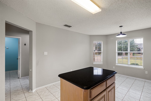 kitchen featuring hanging light fixtures, a textured ceiling, and a kitchen island