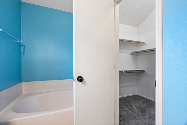 bathroom with a bath and a textured ceiling