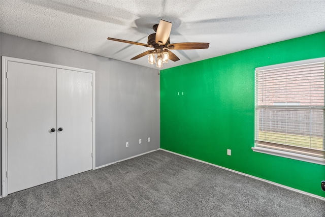 unfurnished bedroom with ceiling fan, a textured ceiling, carpet flooring, and a closet