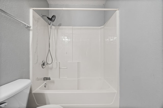 bathroom with tiled shower / bath combo and toilet