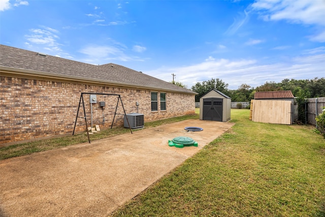 view of yard featuring central AC unit, a patio area, and a shed