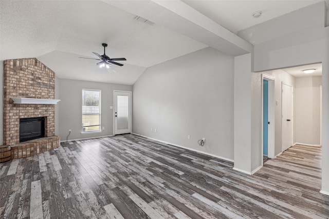 unfurnished living room featuring hardwood / wood-style floors, vaulted ceiling, ceiling fan, and a fireplace