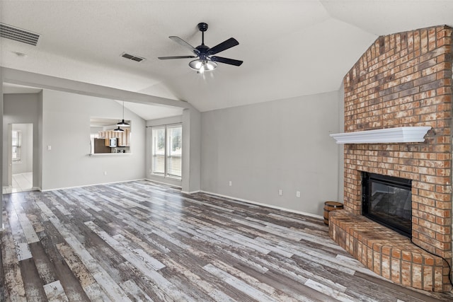 unfurnished living room featuring hardwood / wood-style floors, a fireplace, and vaulted ceiling