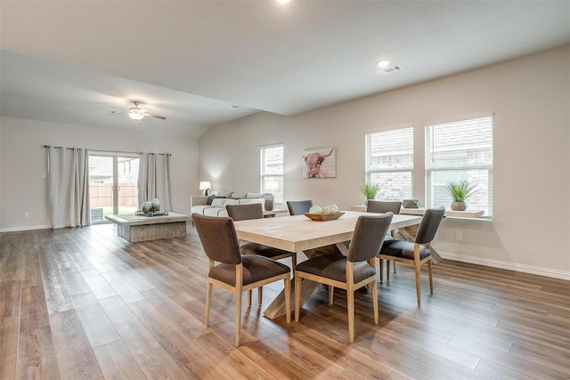 dining room featuring vaulted ceiling, hardwood / wood-style flooring, and ceiling fan