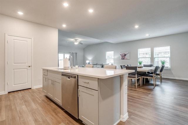 kitchen featuring plenty of natural light, sink, stainless steel dishwasher, and a center island with sink