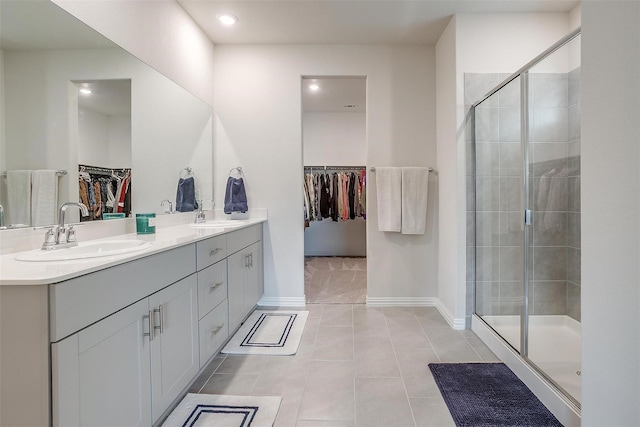 bathroom featuring vanity, a shower with shower door, and tile patterned flooring