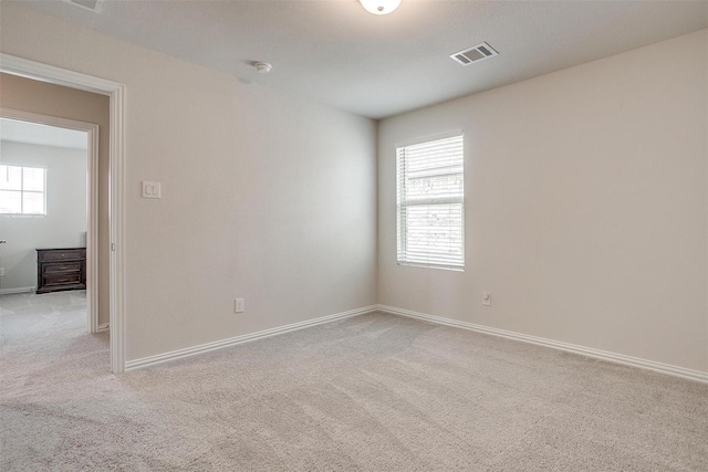 unfurnished room featuring light colored carpet and a wealth of natural light