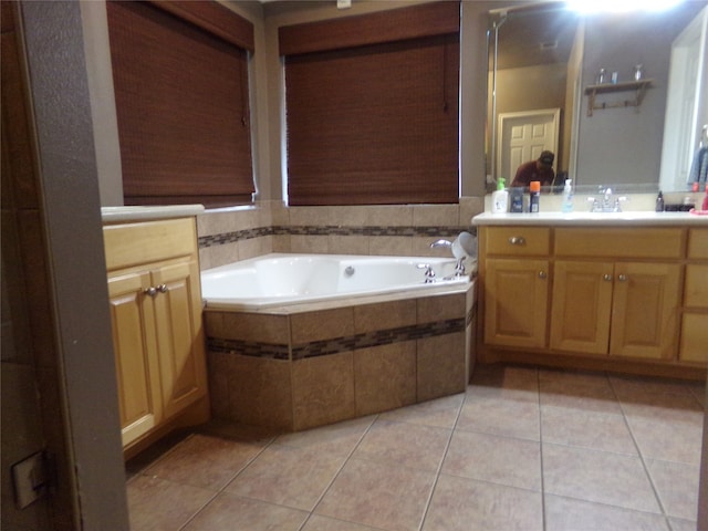 bathroom featuring vanity, tile patterned flooring, and tiled tub