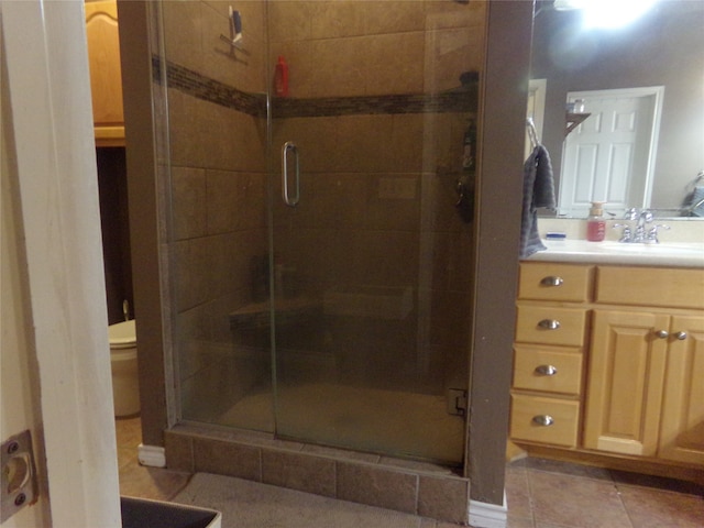 bathroom featuring vanity, walk in shower, tile patterned floors, and toilet