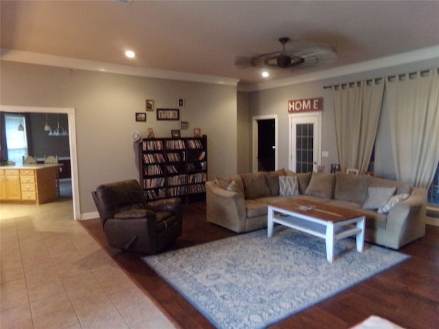 living room with tile patterned flooring, ceiling fan, and crown molding