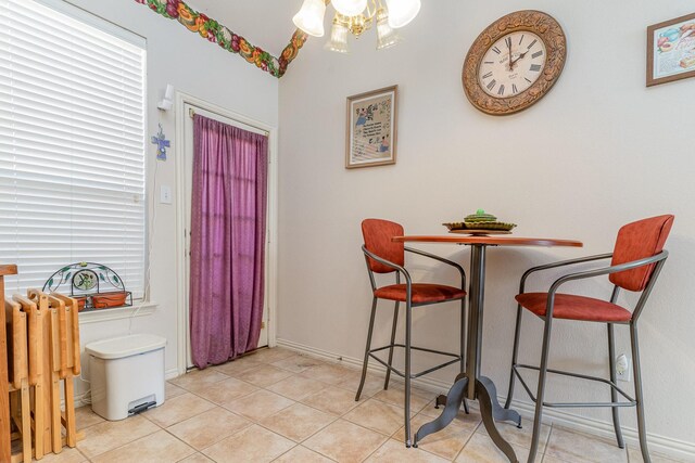 dining area with light tile patterned flooring and a chandelier