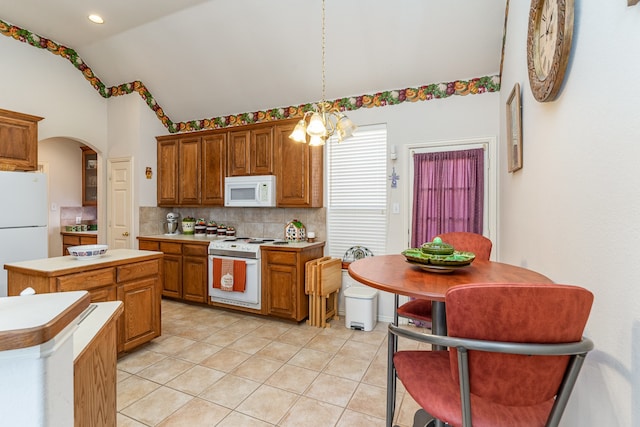 kitchen featuring a center island, hanging light fixtures, light tile patterned floors, white appliances, and decorative backsplash