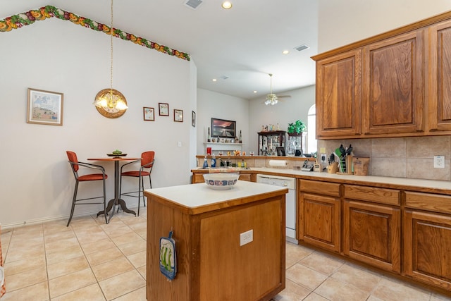 kitchen featuring dishwasher, a center island, tasteful backsplash, light tile patterned flooring, and decorative light fixtures