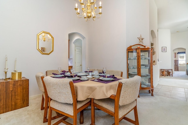 carpeted dining area with an inviting chandelier and a high ceiling