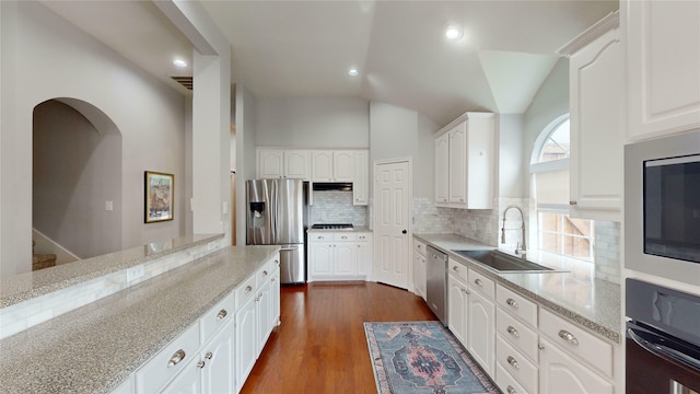 kitchen with sink, dark hardwood / wood-style floors, light stone counters, white cabinetry, and stainless steel appliances