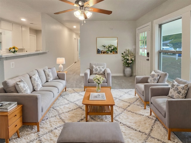 carpeted living room with ceiling fan