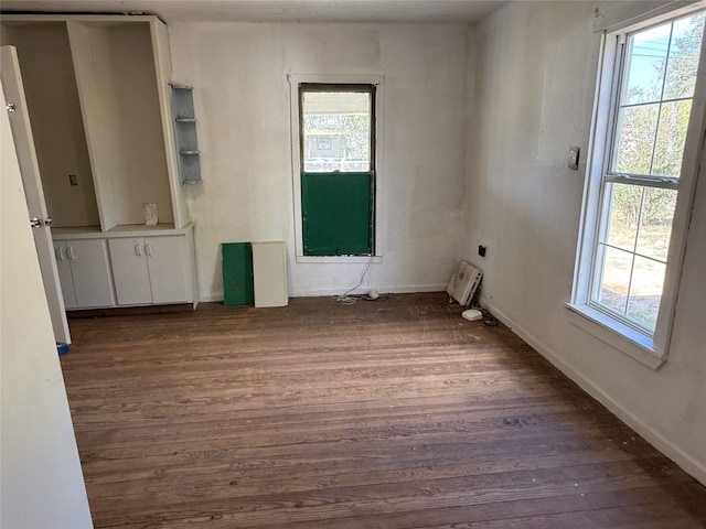 unfurnished room featuring dark wood-type flooring and plenty of natural light