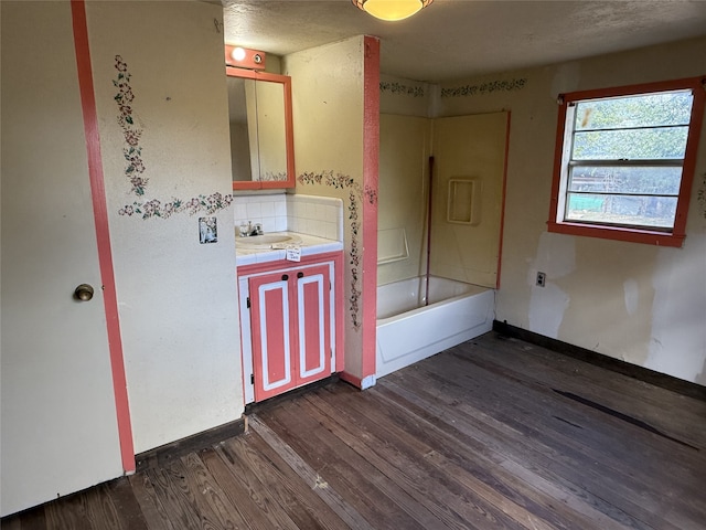 bathroom with vanity, hardwood / wood-style flooring, backsplash, and shower / bathtub combination