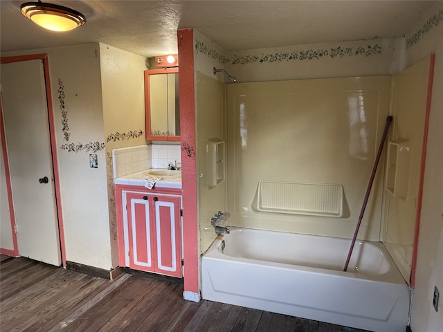 bathroom featuring vanity, tub / shower combination, hardwood / wood-style floors, and decorative backsplash