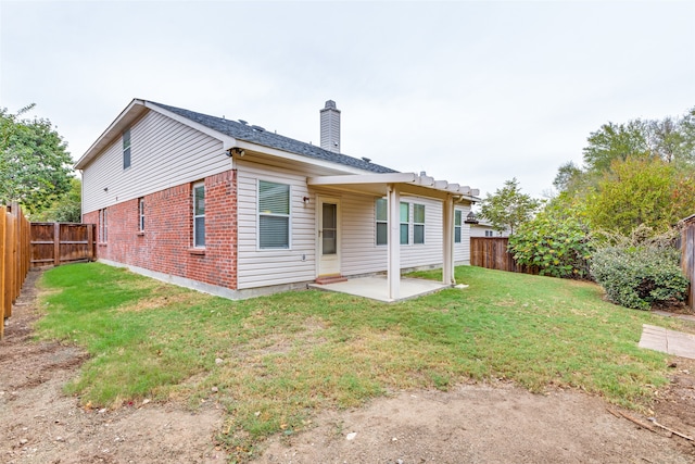 back of house featuring a yard and a patio area