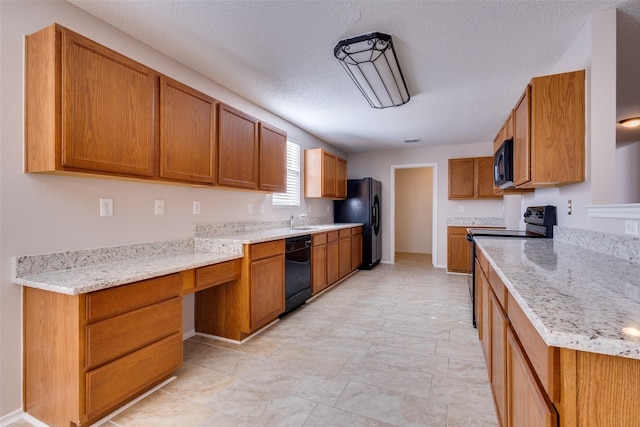 kitchen featuring light stone counters, sink, a textured ceiling, and black appliances