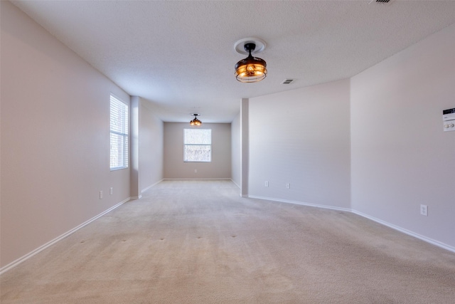 carpeted empty room with a textured ceiling