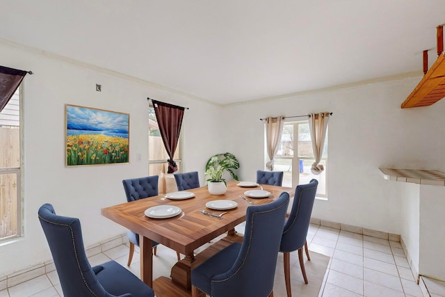 tiled dining room featuring crown molding