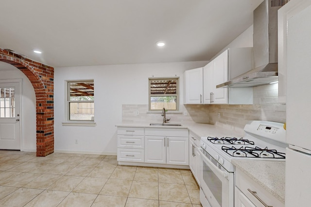 12304 Knight Dr, Balch Springs, TX 75180 - kitchen featuring white range with gas stovetop, wall chimney range hood, healthy amount of natural light, and recessed lighting