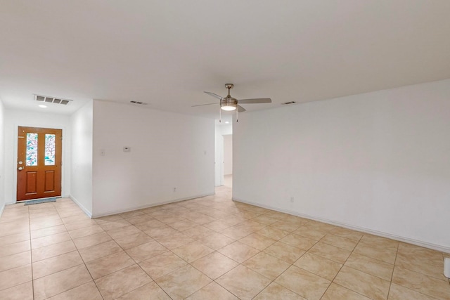 tiled empty room featuring ceiling fan