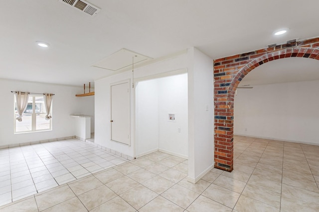 12304 Knight Dr, Balch Springs, TX 75180 - empty room with light tile patterned floors, attic access, arched walkways, and recessed lighting