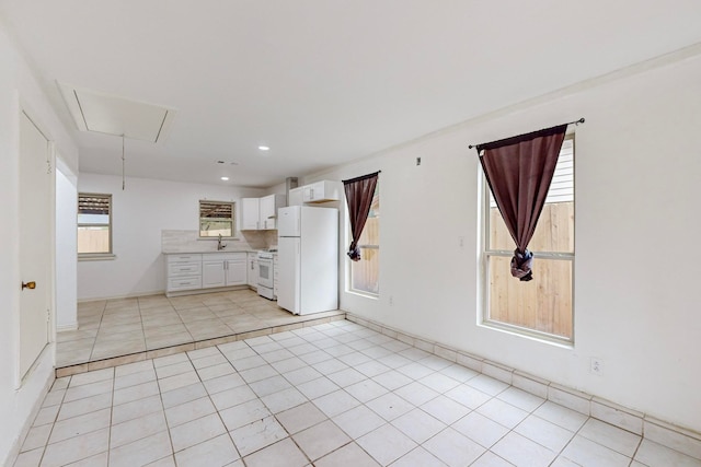 kitchen featuring white appliances, light tile patterned floors, sink, and white cabinets