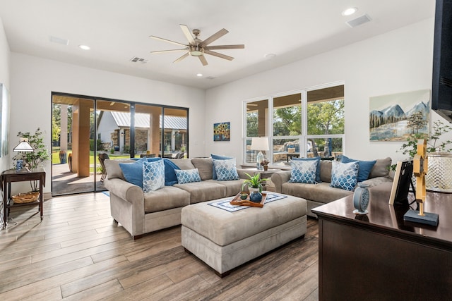 living room with ceiling fan, wood-type flooring, and plenty of natural light