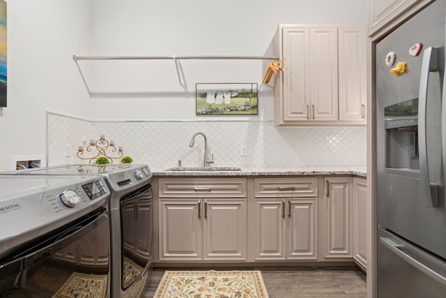 laundry room with sink, washing machine and clothes dryer, cabinets, and dark hardwood / wood-style flooring