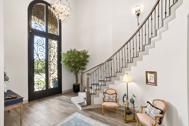 foyer entrance with a towering ceiling, hardwood / wood-style floors, and a wealth of natural light